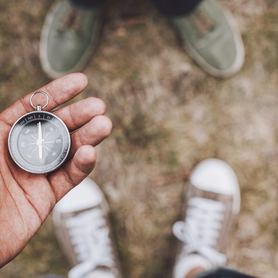 Hipster traveler holding compass in hand